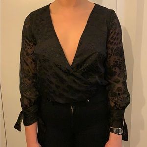 patterned see thru body suit with ties at wrists.